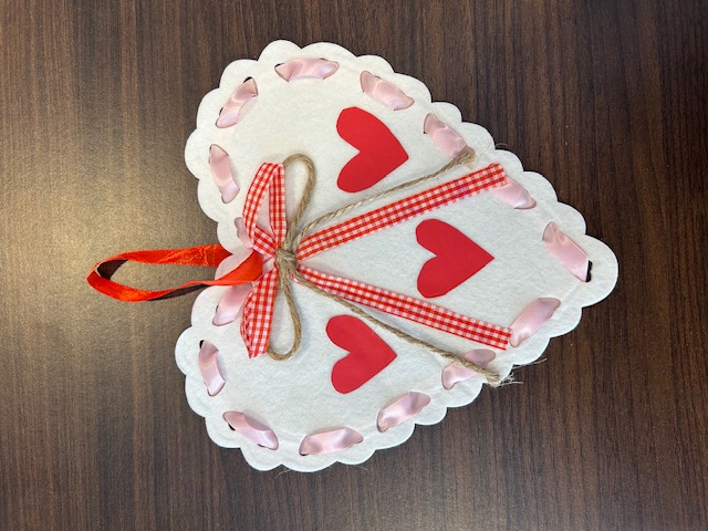 White felt heart craft decorated with ribbon and hearts