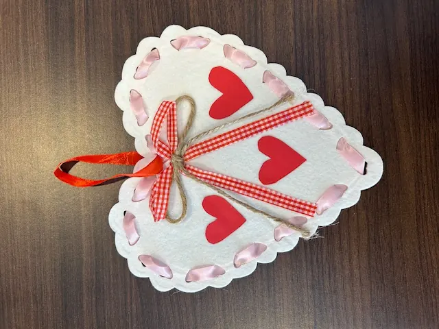 White felt heart craft decorated with ribbon and hearts