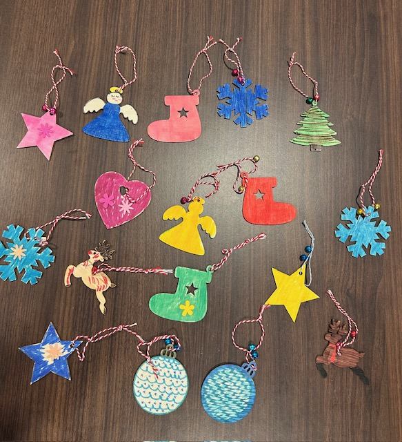 Hand-decorated wooden holiday ornaments shaped like stars, angels, and snowflakes