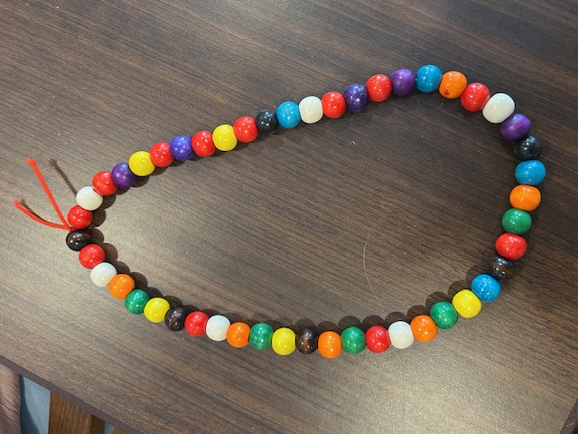 Long beaded necklace in red, yellow, green, and blue