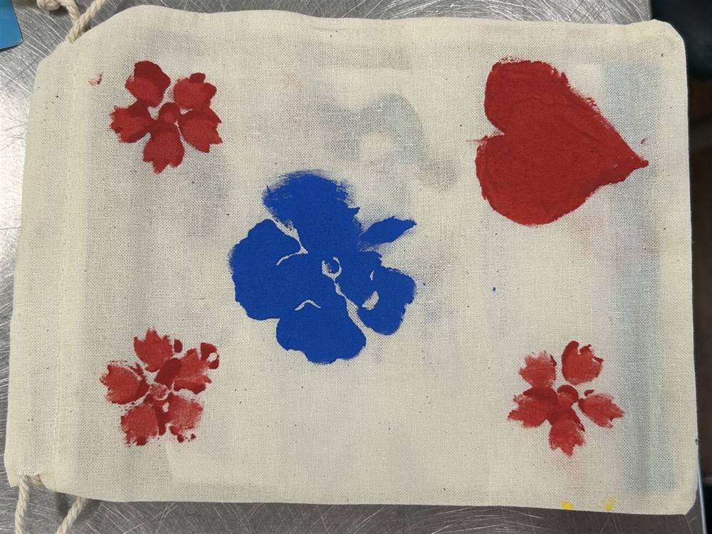 Hand-painted drawstring bag with floral and heart designs