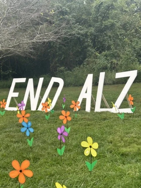 Large "END ALZ" letters on the grass surrounded by colorful pinwheel flowers
